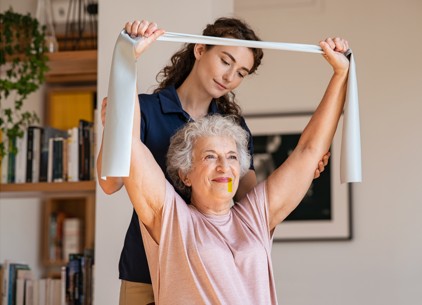 home caregiver helping to support a senior with physical health, activity as part of post hospital recovery